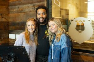 OBC employee with two restaurant guests for picture at host desk