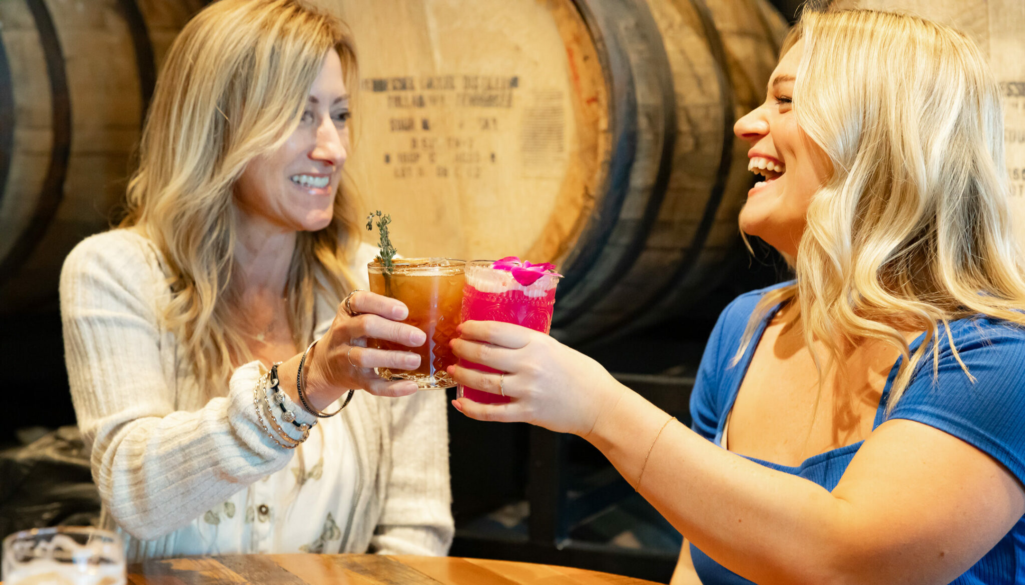 Two friends toasting each other with craft cocktails at Oscar’s Brewing Company, one of the best restaurants in Temecula.