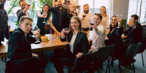 A happy group of people celebrating and drinking red wine in a private party space at OBC restaurant in Temecula.