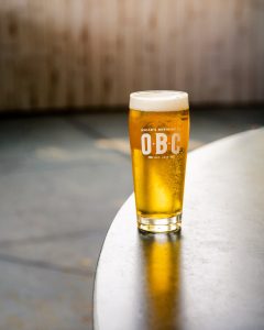 A chilled pint of craft beer served on a table in a bright restaurant setting.